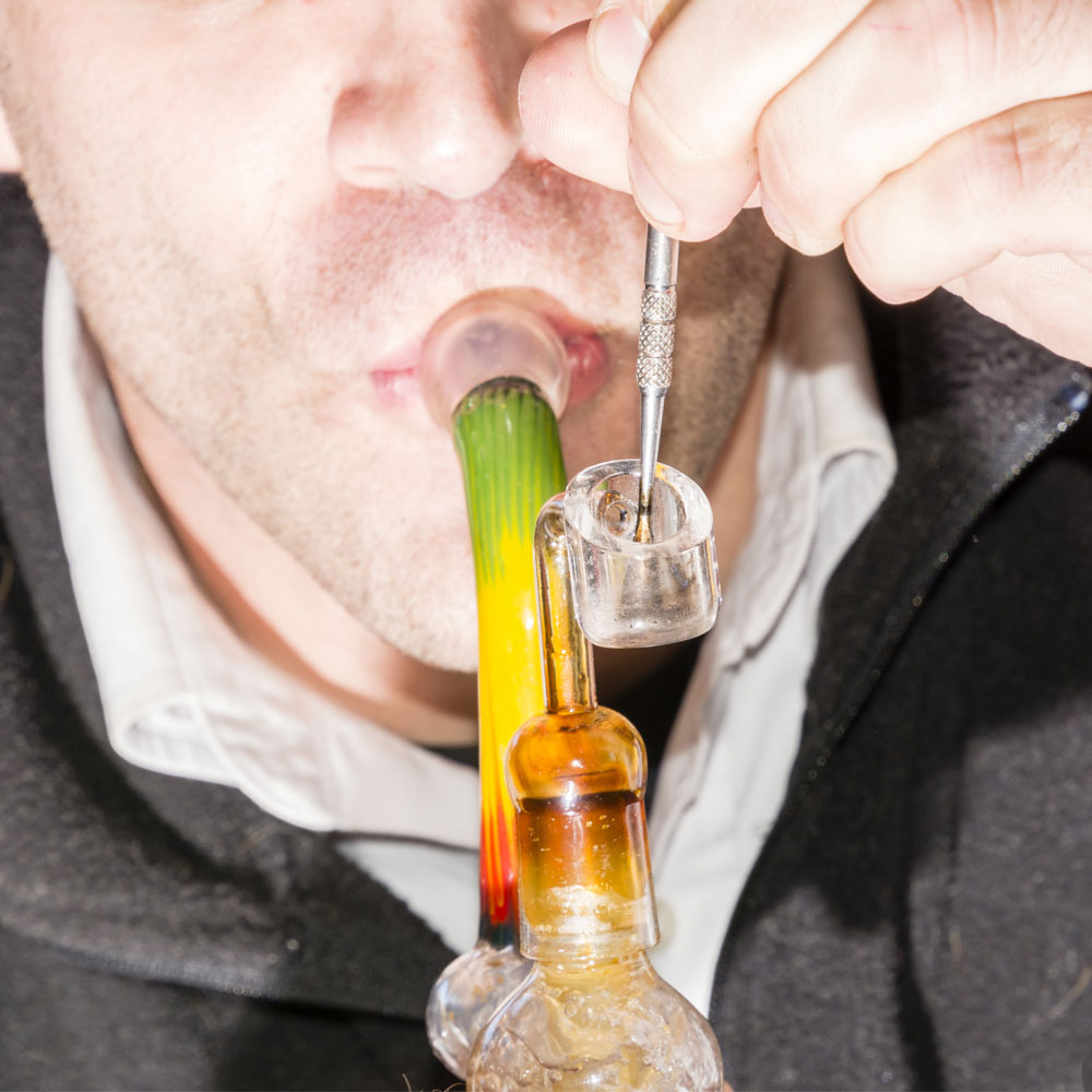 A man taking a dab from a dab rig
