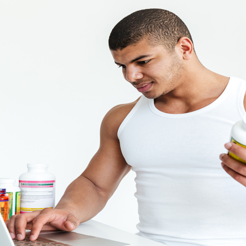 Athletic man holding pill bottle