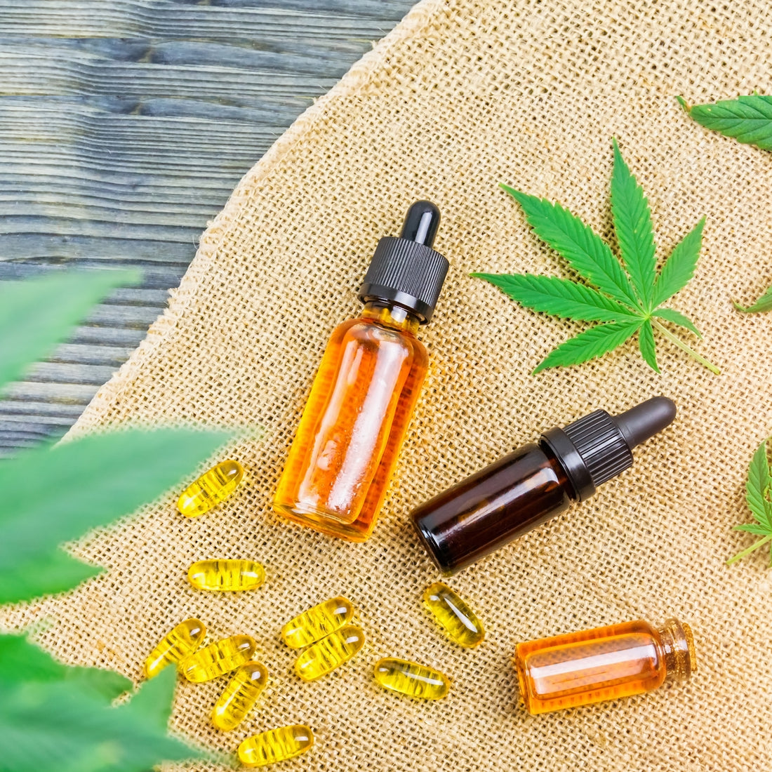 CBD Capsules and Tinctures on top of burlap mat