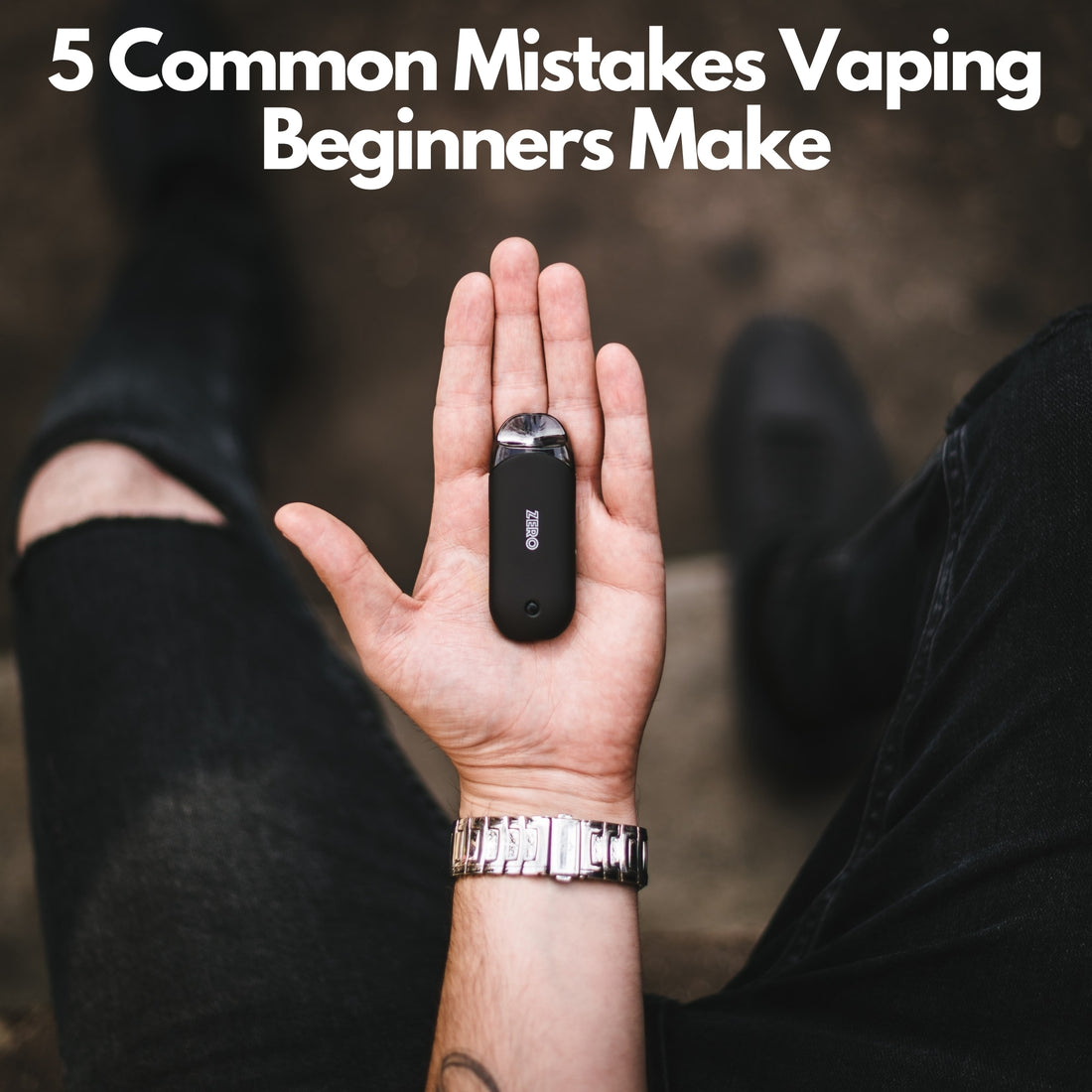 Black mini vaporizer in hand with black cut jeans on