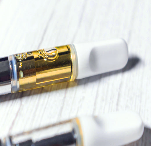 Two vape cartridges on a flat table