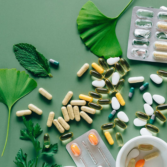 Medications scattered on table around flower petals