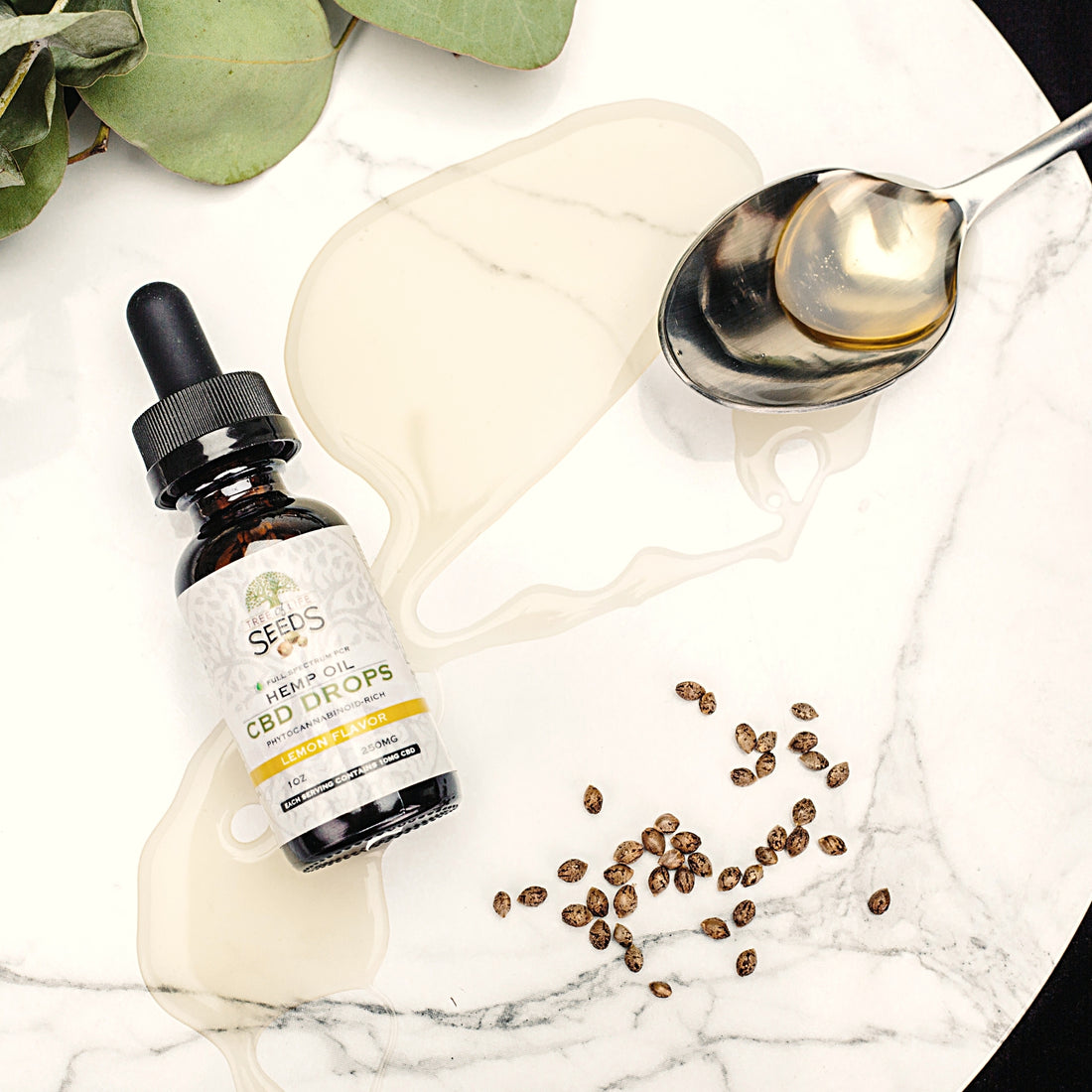 Hemp oil cbd drops tincture on table with spoon and hemp seeds