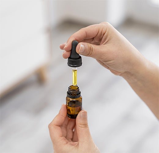 A man squeezes dropper with oil