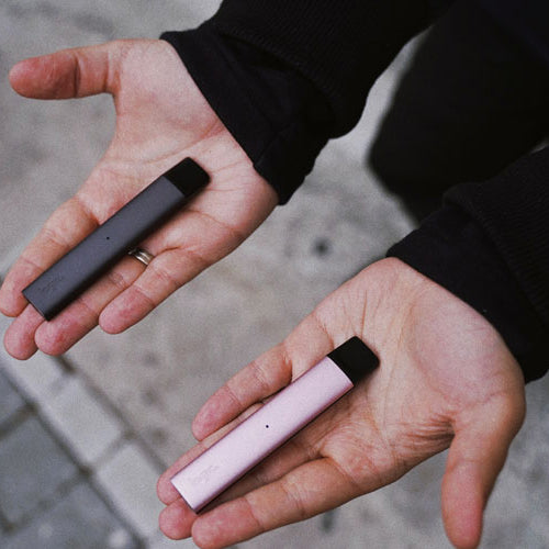 Man holding two vape pens