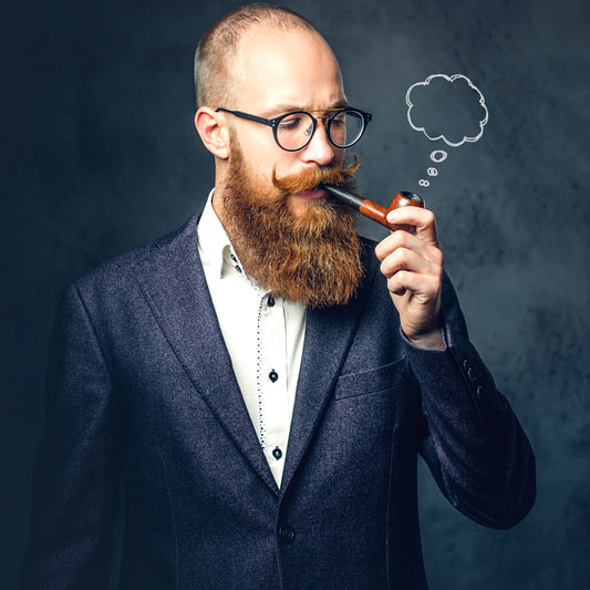 A suited man in glasses smoking a pipe