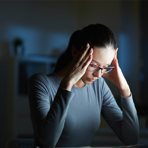 Woman in front of computer has headache 