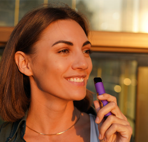 Smiling woman vaping from a disposable vape